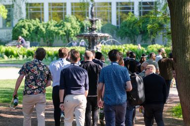 Group of guests walking towards a fountain in a park at myConf 2024.