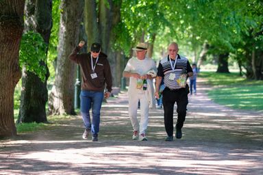 Three guests chatting while walking in a park at myConf 2024.