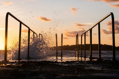 black metal railings on body of water